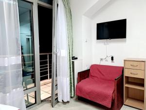 Habitación con silla roja y balcón. en HOTEL Crystal Lights, en Pirot