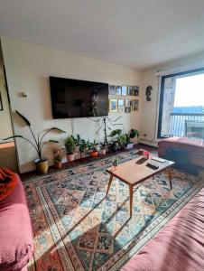 a living room with a table and a large rug at Stylish Downtown Calgary Home in Calgary