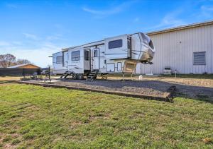 una caravana estacionada frente a un edificio en Cozy 2-Guest RV on Nature Farm, en Pine Grove