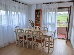 comedor con mesa, sillas y ventana en Villa en la costa, en Santander