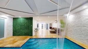 a swimming pool in a room with a green wall at The Blue Water House in San Juan