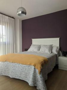 1 dormitorio con cama y pared púrpura en Villa en la costa, en Santander