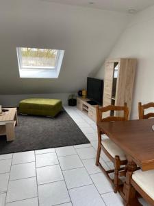 uma sala de estar com uma mesa e um repousa-pés verde em Ferienwohnung am Erbacher Mümlingufer em Erbach