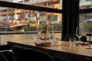 una mesa en un restaurante con copas de vino. en H2OTEL Rotterdam, en Róterdam