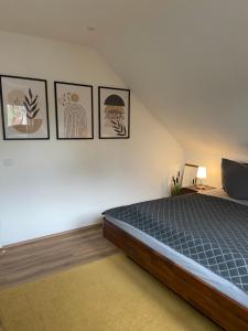 ein Schlafzimmer mit einem Bett und vier Bildern an der Wand in der Unterkunft Ferienwohnung am Erbacher Mümlingufer in Erbach
