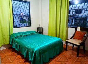 - une chambre avec des rideaux verts, un lit et une chaise dans l'établissement Amplio y cómodo departamento con garaje., à Puyo