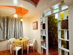 une salle à manger avec une table et des chaises blanches dans l'établissement Amplio y cómodo departamento con garaje., à Puyo