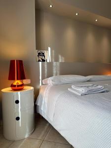 Casa Cavour في مستربيانكو: غرفة نوم بسرير ومصباح على موقف ليلي