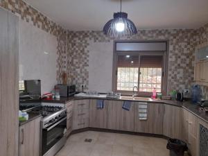 a kitchen with a sink and a stove top oven at Wild strawberry Farm Ajloun مزرعة القيقب عجلون in Ishtafaynā