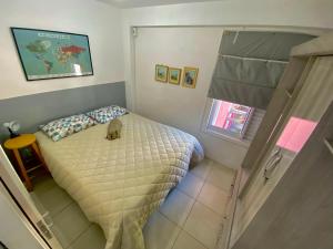 un dormitorio con una cama con un gato sentado en ella en Apartamento Floripa 16 - Próximo Ao Centro, UFSC, Aeroporto e Praias en Florianópolis