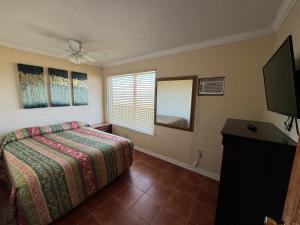 um quarto com uma cama e uma televisão de ecrã plano em Southwind Inn em Port Isabel