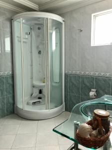 a bathroom with a shower with a bowl on a glass table at Casa Blanca in La Vega