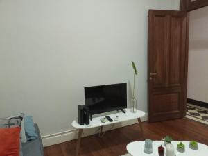 - un salon avec une télévision sur une table blanche dans l'établissement PLAZA SAN MARTIN, à Buenos Aires