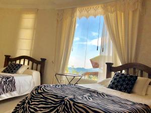 a bedroom with two beds and a large window at Casa Blanca in La Vega