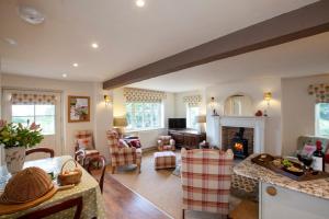 Anvil Cottage في Grewelthorpe: غرفة معيشة مع طاولة ومدفأة