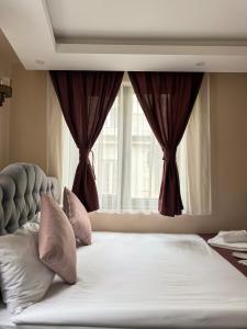 a bedroom with a large bed with a window at Asmali Pera Hotel in Istanbul
