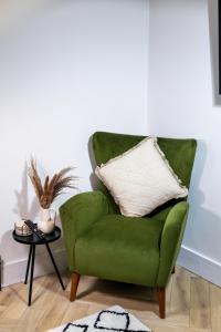 a green chair in a living room with a table at Skegness Luxury 2 bedroom apartment , sleeps 6 people in Lincolnshire