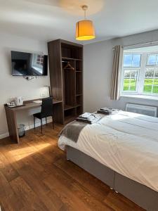 1 dormitorio con cama, escritorio y ventana en The Watling Inn, en Nuneaton