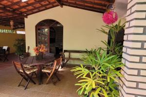 a patio with a table and chairs and plants at Nana's House Vilas in Lauro de Freitas
