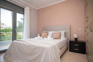 Schlafzimmer mit einem großen weißen Bett und einem Fenster in der Unterkunft La Vie Villa in Zakynthos
