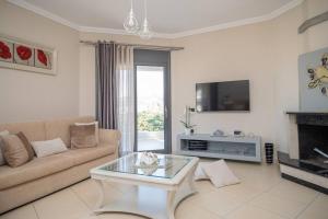 a living room with a couch and a tv at La Vie Villa in Zakynthos
