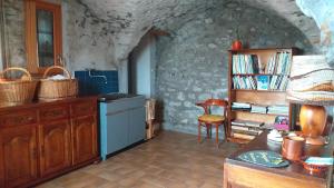 a kitchen with a counter and a table and a shelf at GITE AUBERGE DU BUECH à ASPREMONT- 05 HAUTES ALPES in Aspremont