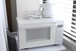 a microwave oven with a blender on top of it at SLEEPLAB 高輪 -睡眠特化型Hotel- in Tokyo