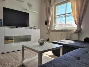 Ferienwohnung Seebrise في ساسنيتز: غرفة معيشة مع تلفزيون وأريكة