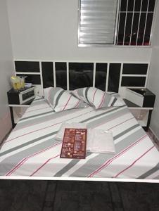 a bed with two pillows and a book on it at Hotel Endless Love in Carapicuíba +29 photos