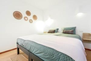 1 dormitorio con 1 cama y 2 sombreros en la pared en Casa Bernia Vista, en Benitachell