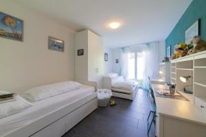 a bedroom with a large white bed and a desk at Sunnewies in Wildhaus