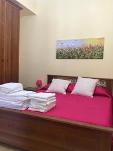 a bedroom with a bed with pink sheets and a painting at Villino Giulia in Altavilla Milicia