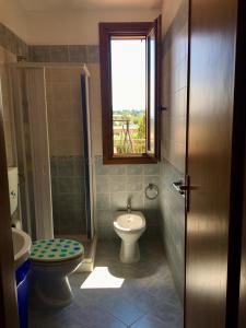 a bathroom with a toilet and a sink and a window at Villino Giulia in Altavilla Milicia