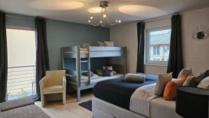 ein Schlafzimmer mit einem Etagenbett und einem Stuhl in der Unterkunft Gästehaus Ferienwohnung Abendstern in Rust