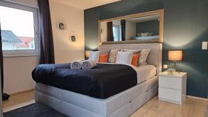 ein Schlafzimmer mit einem großen Bett und einem großen Spiegel in der Unterkunft Gästehaus Ferienwohnung Abendstern in Rust