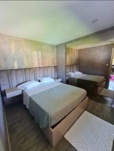 a bedroom with two beds and a large mirror at Casas do Picoutinho in Ponte de Lima