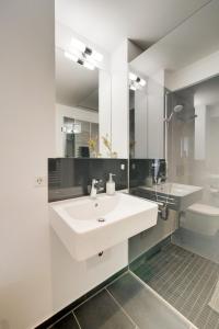 a white bathroom with a sink and a toilet at Altstadt Apartment 2 Zimmer am Weibermarkt in Reutlingen