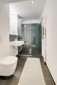 a bathroom with a white toilet and a sink at Altstadt Apartment 2 Zimmer am Weibermarkt in Reutlingen