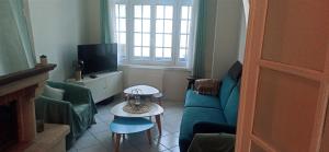 ein Wohnzimmer mit Sofa und Fernseher in der Unterkunft Berthe Lydie Cottage Charme, Confort et Mer in Fort-Mahon-Plage