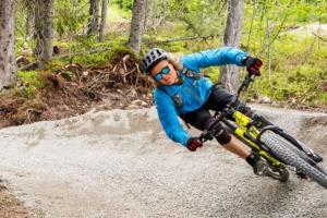 a man riding a bike down a dirt road at Aktiv familjesemester i Lindvallen. MTB, downhill, vandring, sommarskidåkning & bad. 30:e juni till 6:e juli in Sälen