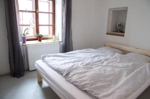an unmade bed in a bedroom with a window at Apartmán Sedlecká v centru Kutné Hory in Kutná Hora