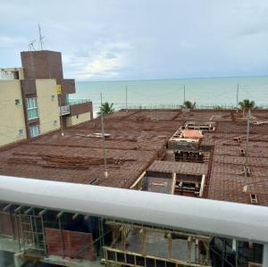 una vista de un edificio con el océano en el fondo en Flat vista mar de Intermares completíssimo 508, en João Pessoa