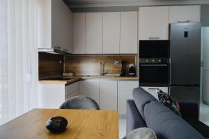 a kitchen with a couch and a table and a refrigerator at Faros Flat in Alexandroupoli