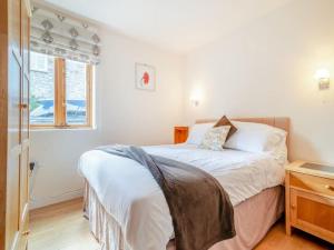 1 dormitorio con cama y ventana en The Burcott Inn Cottages, en Wells