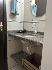 W łazience znajduje się umywalka i lustro. w obiekcie Casa Recanto Aconchego 1 w mieście Sorriso
