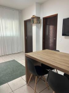 Pokój z drewnianym stołem i 2 krzesłami w obiekcie Casa Recanto Aconchego 1 w mieście Sorriso