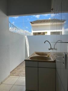 a kitchen with a sink and a view of a building at Casa Recanto Aconchego 1 in Sorriso