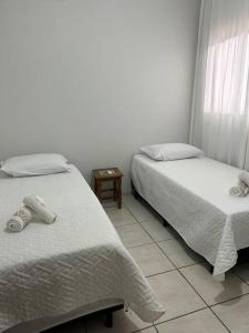 sypialnia z 2 łóżkami i podłogą wyłożoną kafelkami w obiekcie Casa Recanto Aconchego 1 w mieście Sorriso