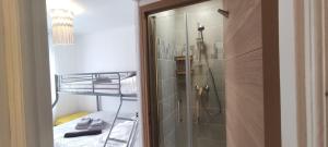 ein kleines Bad mit Dusche und ein Bett in der Unterkunft Berthe Lydie Cottage Charme, Confort et Mer in Fort-Mahon-Plage + 16 Fotos