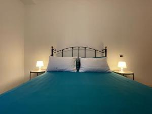 a green bed with two lamps on two tables at Yas Marina (Maison Porto Canale) in Cesenatico +3 photos